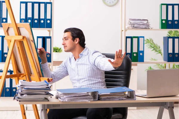 Joven empleado guapo disfrutando de la pintura en la oficina — Foto de Stock