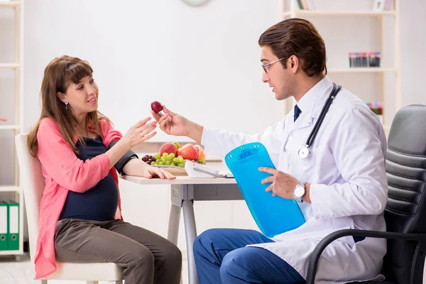 Hamile kadın doktoru ziyaret edip sağlıklı beslenmeyi tartışıyor. — Stok fotoğraf