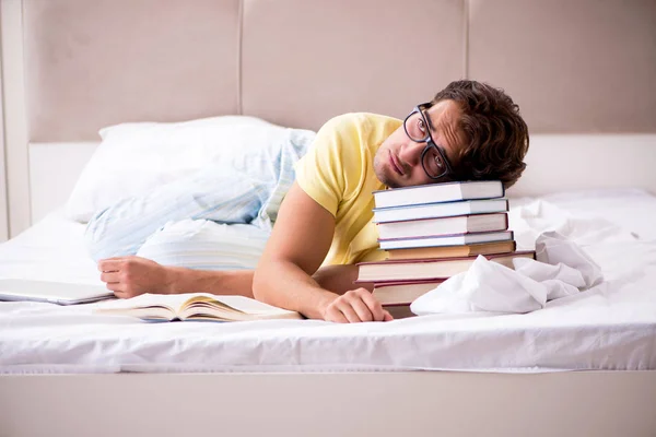 Estudiante joven estudiando en la cama para exámenes — Foto de Stock