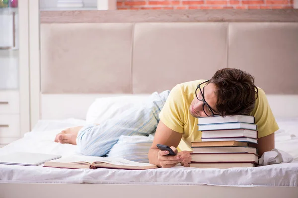 Giovane studente che studia a letto per gli esami — Foto Stock