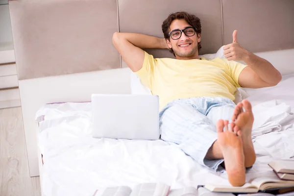 Giovane studente che studia a letto per gli esami — Foto Stock