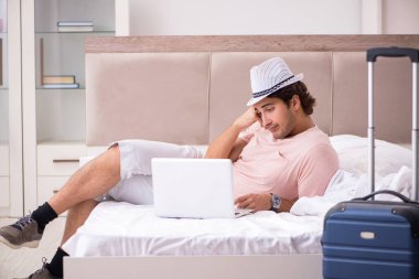 Bavul seyahat için bekleyen yatak odasında olan adam 