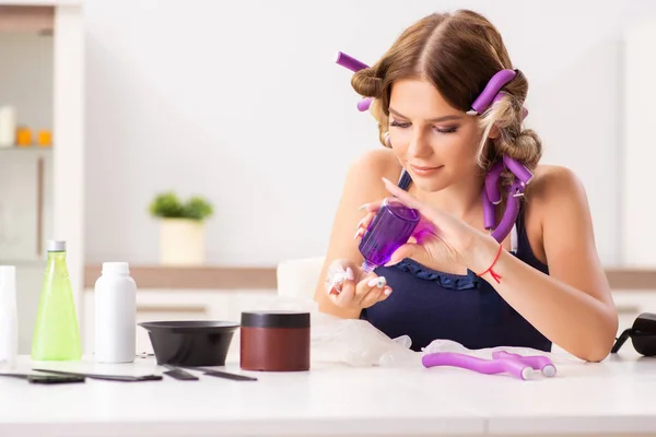 Jeune femme avec des bigoudis au salon de coiffure — Photo