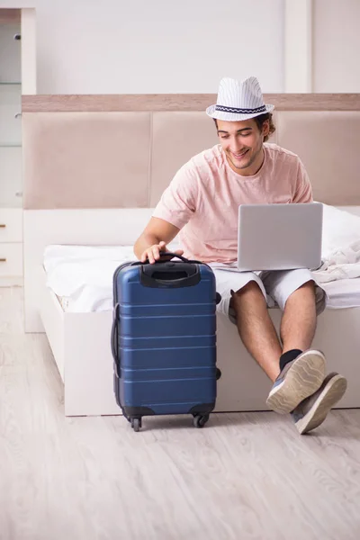 Homem com mala no quarto à espera de viagem — Fotografia de Stock