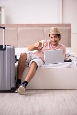 Bavul seyahat için bekleyen yatak odasında olan adam 