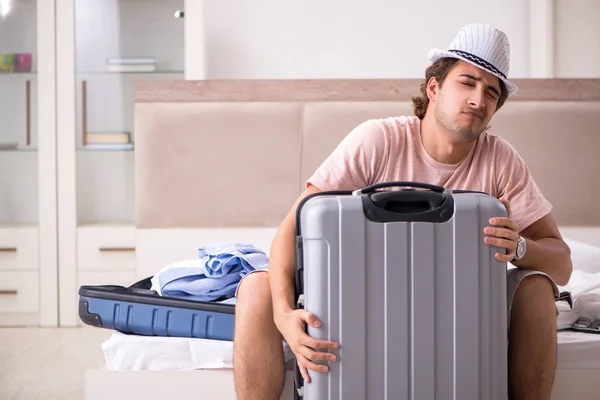 Muž s kufrem v ložnici čeká na výlet — Stock fotografie