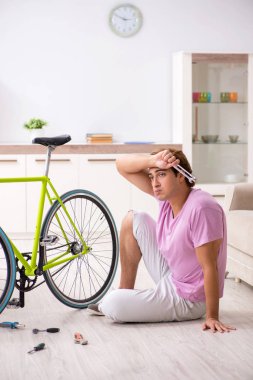 Kırık bisikletini tamir eden adam.