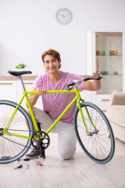 Kırık bisikletini tamir eden adam.