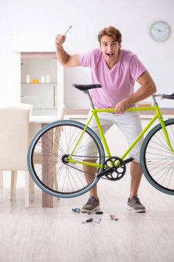 Kırık bisikletini tamir eden adam.