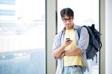 Genç yakışıklı öğrenci pencerede duruyor. 