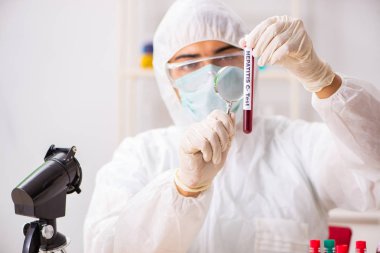 Genç yakışıklı laboratuvar asistanı hastanede kan örnekleri test ediyor. 