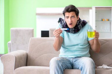 Evde hastalıktan muzdarip genç yakışıklı bir adam. 