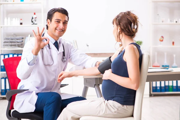 妊婦の血圧をチェックする若い医師 — ストック写真