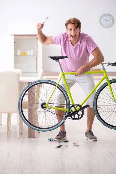 Kırık bisikletini tamir eden adam.