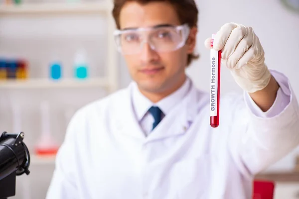 Asistente de laboratorio joven guapo analizando muestras de sangre en el hospital — Foto de Stock