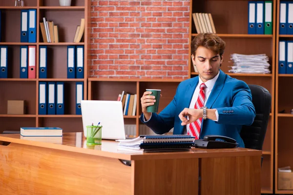 Joven empleado guapo sentado en la oficina — Foto de Stock