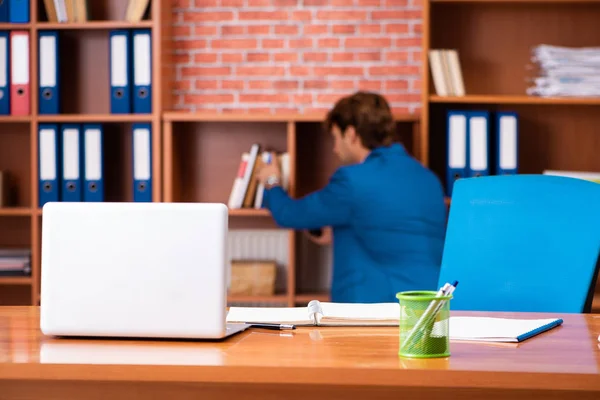 Joven empleado guapo sentado en la oficina — Foto de Stock