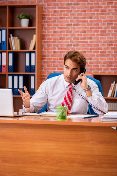 Jeune beau employé assis dans le bureau — Photo