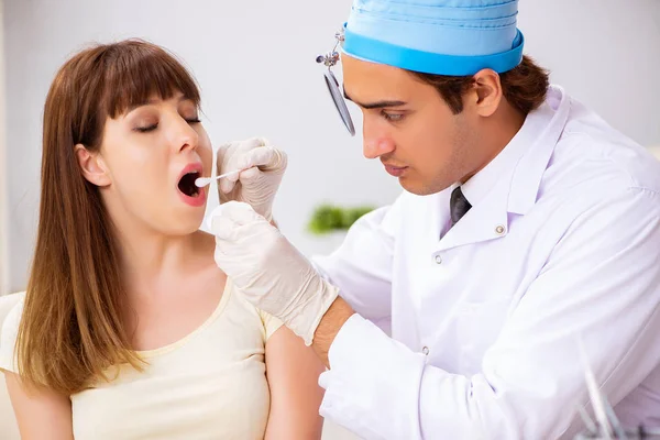 Jeune femme visitant le médecin masculin otolaryngologue — Photo