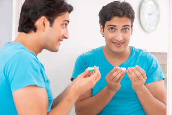 Homem tentando lentes de contato em casa — Fotografia de Stock