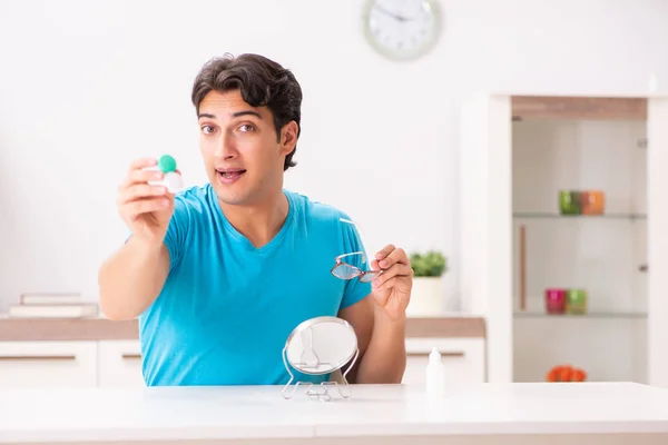 Hombre tratando de lentes de contacto en casa —  Fotos de Stock