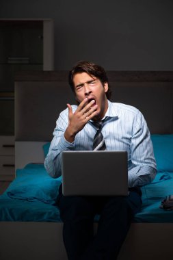 Yorgun işadamı gece fazla mesai yapıyor.