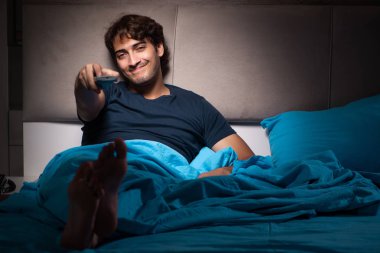 Gece yatakta TV izleyen adamım
