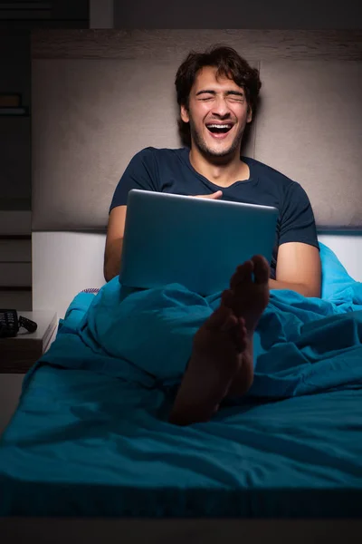 Homme travaillant sur ordinateur portable la nuit au lit — Photo