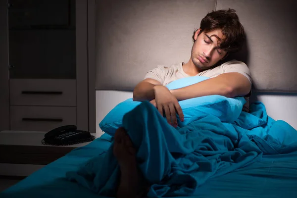 피곤된 피곤된 사람이 그의 침대에서 자 고 — 스톡 사진