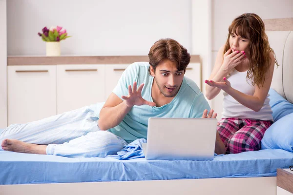 Jeune couple avec ordinateur portable dans la chambre — Photo
