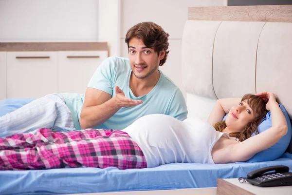 Gravid kvinna med man i sovrummet — Stockfoto