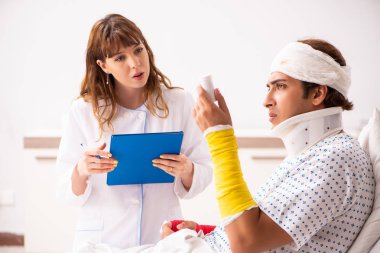 Genç doktor yaralı hastayı muayene ediyor. 