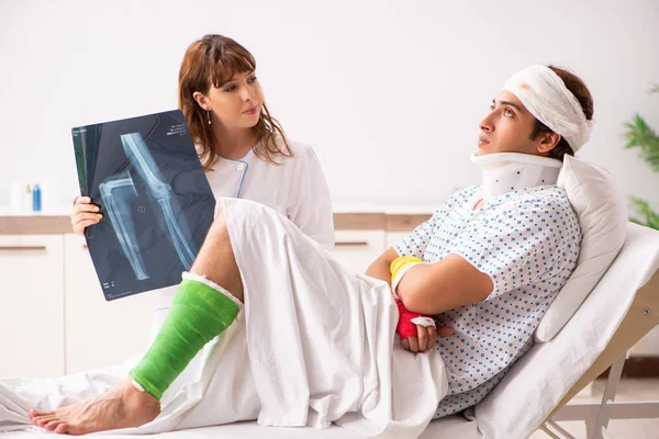 Ung läkare undersöker skadad patient — Stockfoto