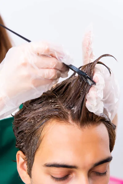 Parrucchiere donna applicando tintura ai capelli dell'uomo — Foto Stock