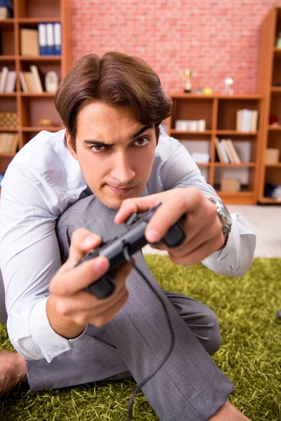 Jovem funcionário jogando joystick jogos durante sua pausa — Fotografia de Stock