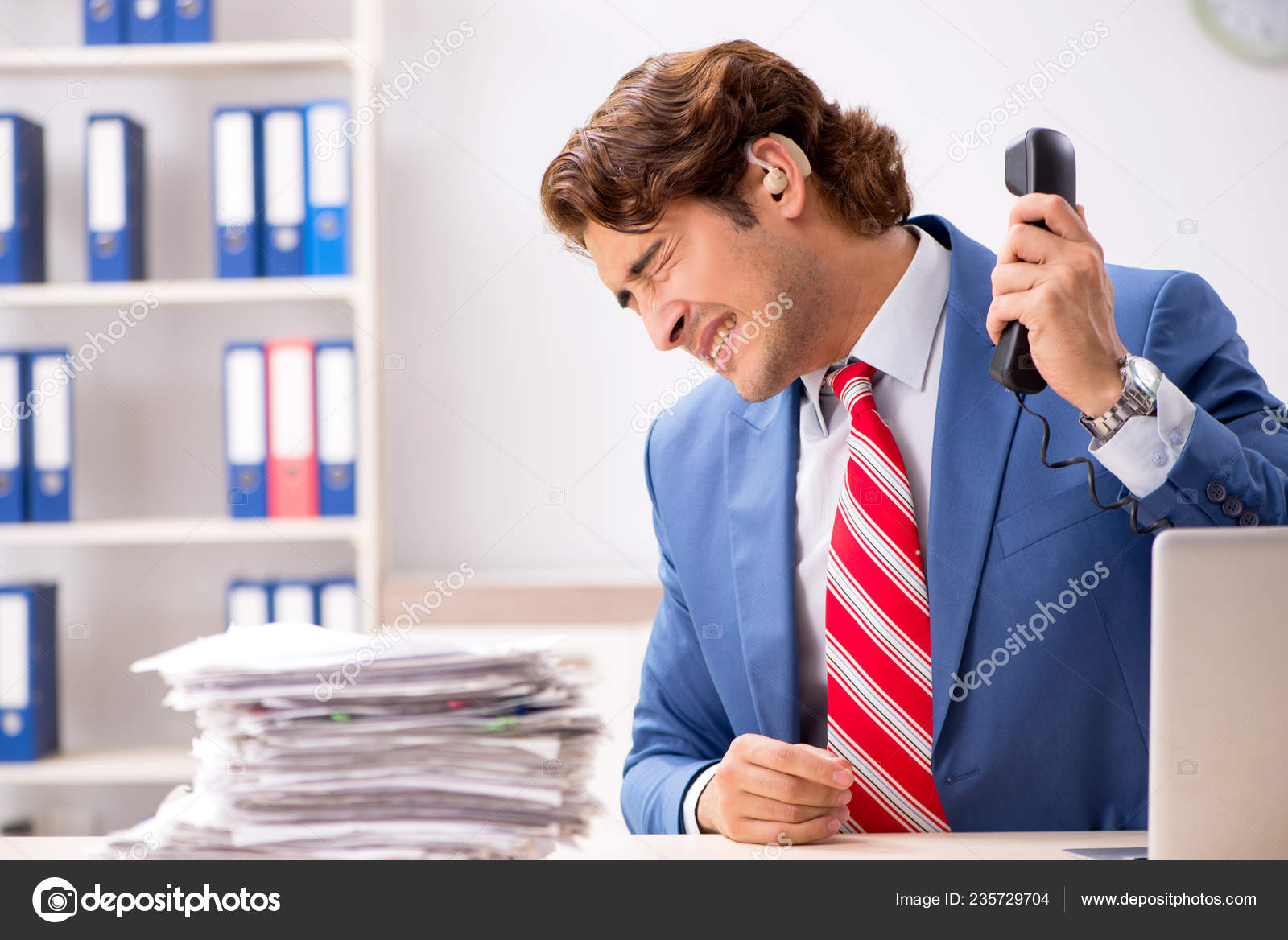 Deaf employee using hearing aid in office Stock Photo by ©Elnur_ 235729704
