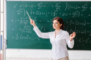 Kara tahta önünde kadın matematik öğretmeni 