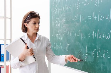 Kara tahta önünde kadın matematik öğretmeni 