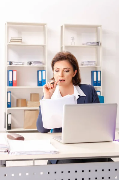 Mitarbeiterin mittleren Alters sitzt im Büro — Stockfoto