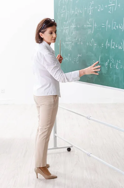 Θηλυκό μαθηματικά δάσκαλος μπροστά από το μαυροπίνακα — Φωτογραφία Αρχείου