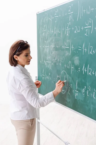 Female math teacher in front of the chalkboard — Stock Photo, Image