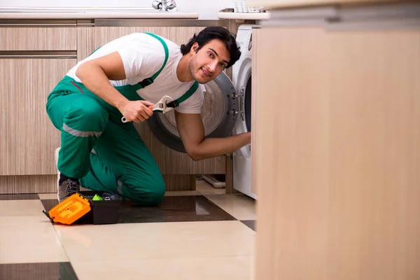 Jungunternehmer repariert Waschmaschine in Küche — Stockfoto