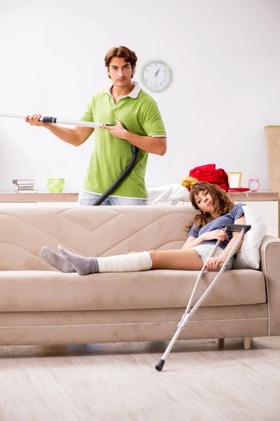 Mari aider femme blessée jambe dans les travaux ménagers — Photo