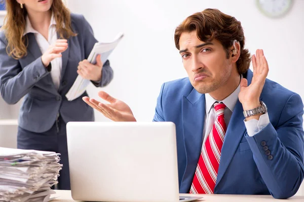 Neslyšící zaměstnanec používající sluchadlo mluvit s šéfem — Stock fotografie