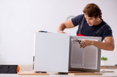 Genç yakışıklı yüklenici tamir buzdolabı 