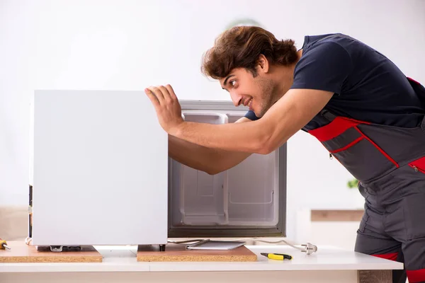 Giovane bello appaltatore riparazione frigo — Foto Stock