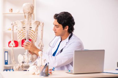 İskeleti olan genç erkek doktor. 