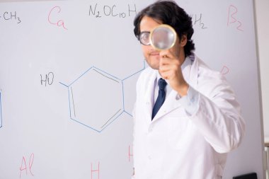 Beyaz tahta önünde genç komik kimyager 
