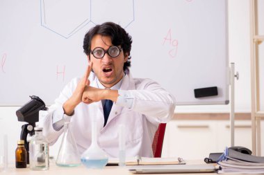Beyaz tahta önünde genç komik kimyager 