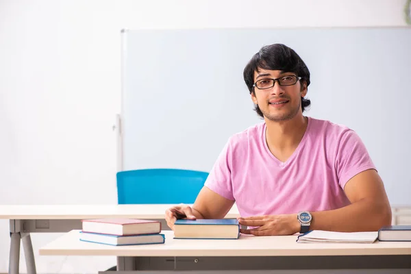 Jovem estudante do sexo masculino sentado na classe — Fotografia de Stock